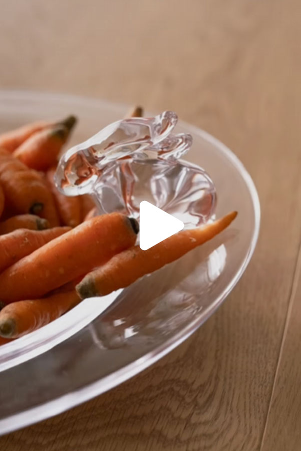 Click here to play the Glass Rabbit Gif. Visual: a glass rabbit perched on the edge of a bowl of carrots